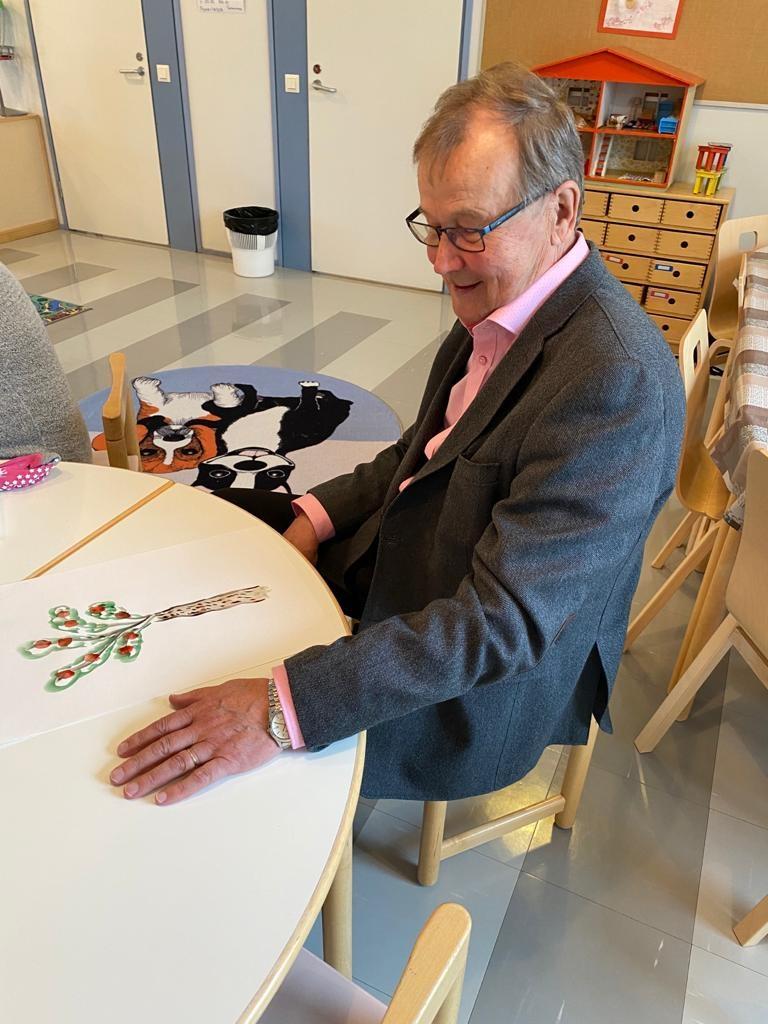 Pekka Kyllönen istuu lasten tuolilla Päivärinteen seurakuntasalissa.