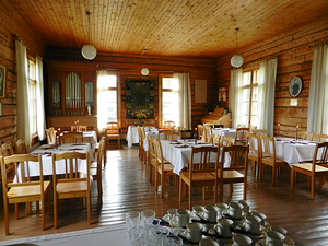Laitasaaren rukoushuone; juhlatilan pöydät valkoisine liinoineen, osa katattua pöytää kahvikuppeineen.